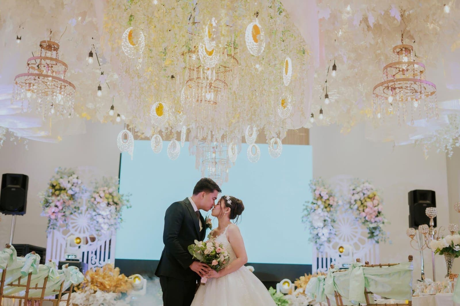 Wedding reception inside the hall with chandeliers and florals